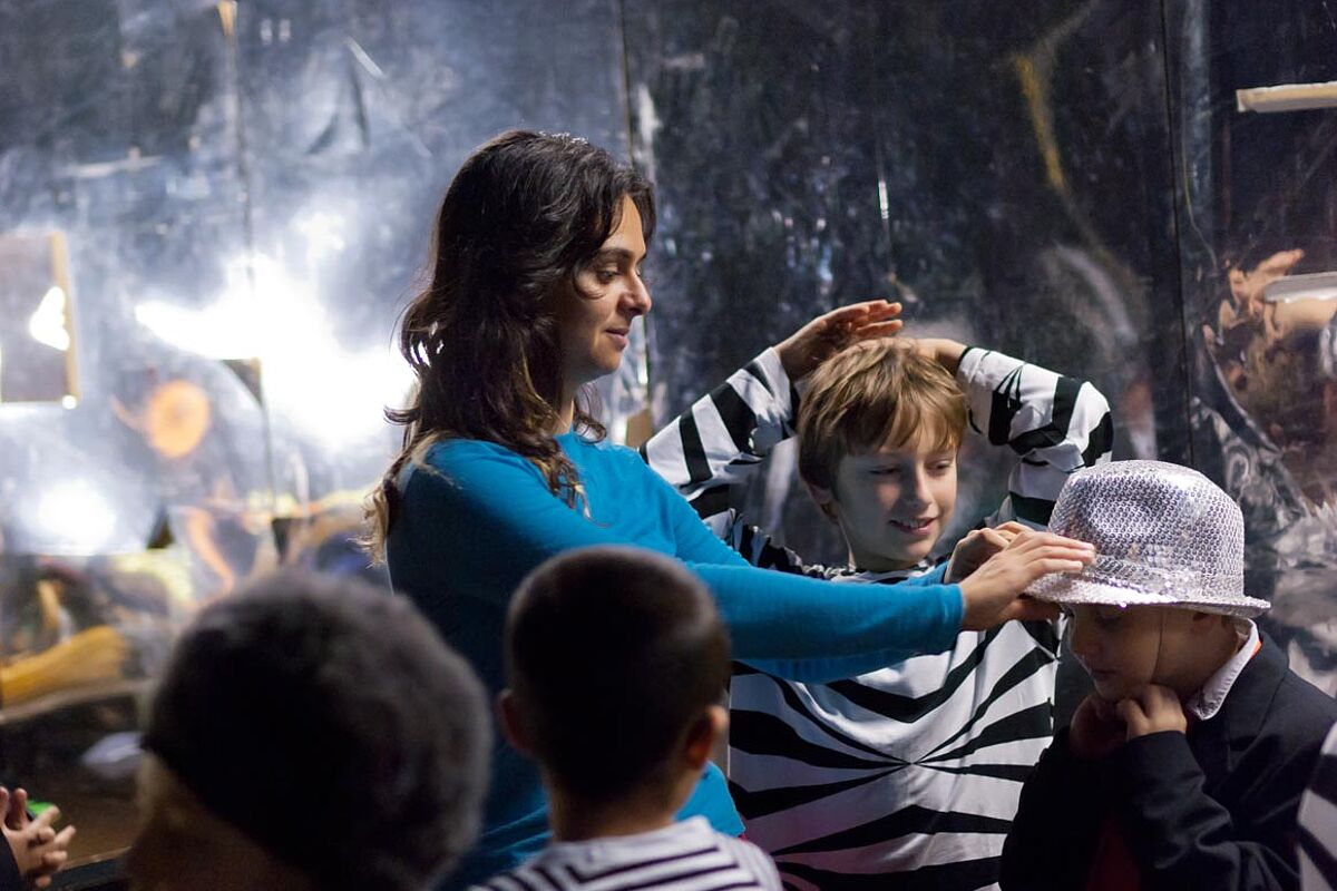 Freiwillige hilft Kindern bei Kostümen