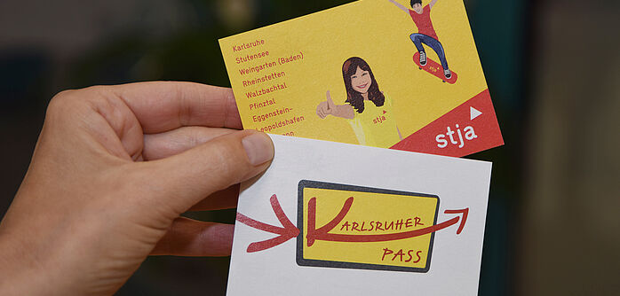 Karlsruher Kinderpass in Papierform Karlsruher Kinderpass in Papierform wird von Hand gehalten