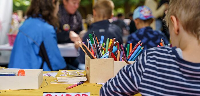 Kufti_Basteln_327 Kind bastelt und malt auf einer Sitzbank
